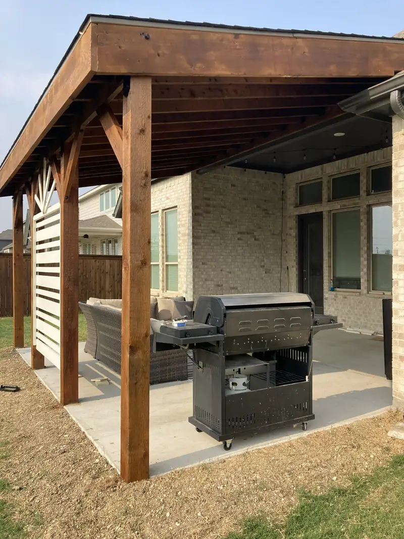 Concrete patio under a cedar patio cover with a horizontal privacy screen