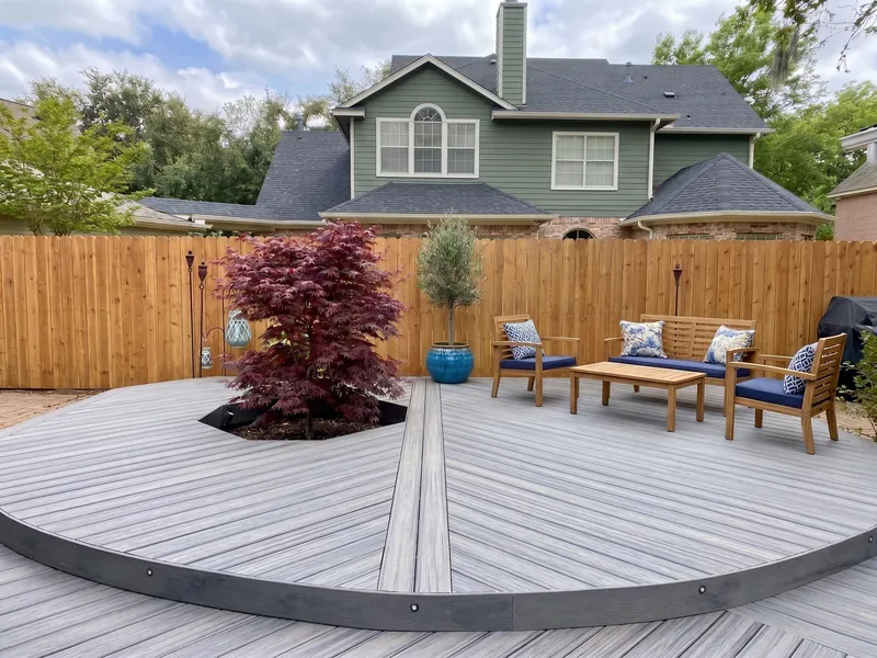 Design example: Gray composite deck built around a tree, with outdoor seating