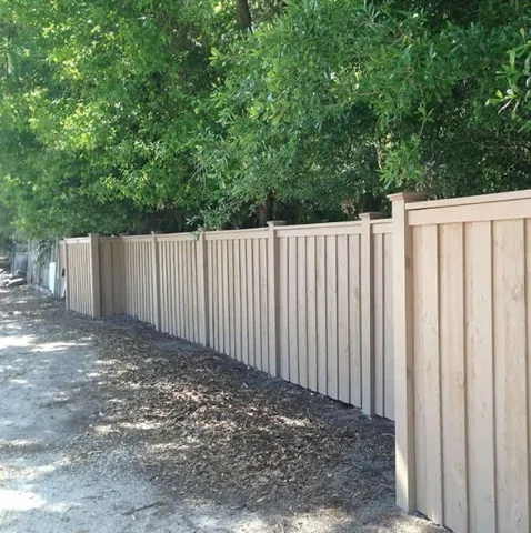 Board-on-board cedar fence with a cap rail along a side yard