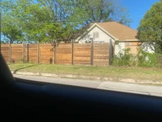 Horizontal cedar fence on steel posts along a street