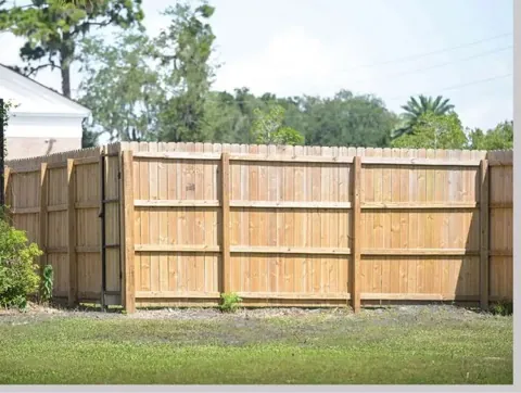 Wood privacy fence with three-rail framing