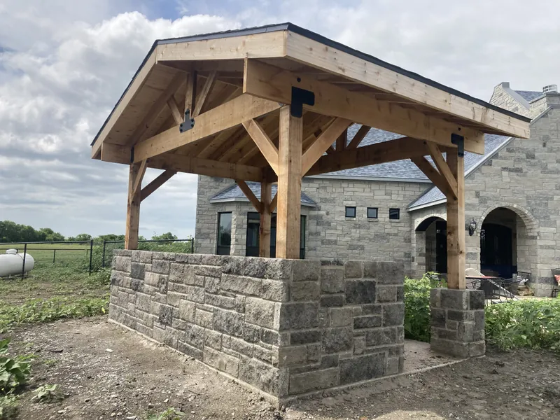 Gable-roof cedar pavilion on a stone knee wall