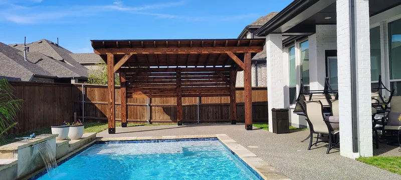 Cedar pergola beside a backyard pool